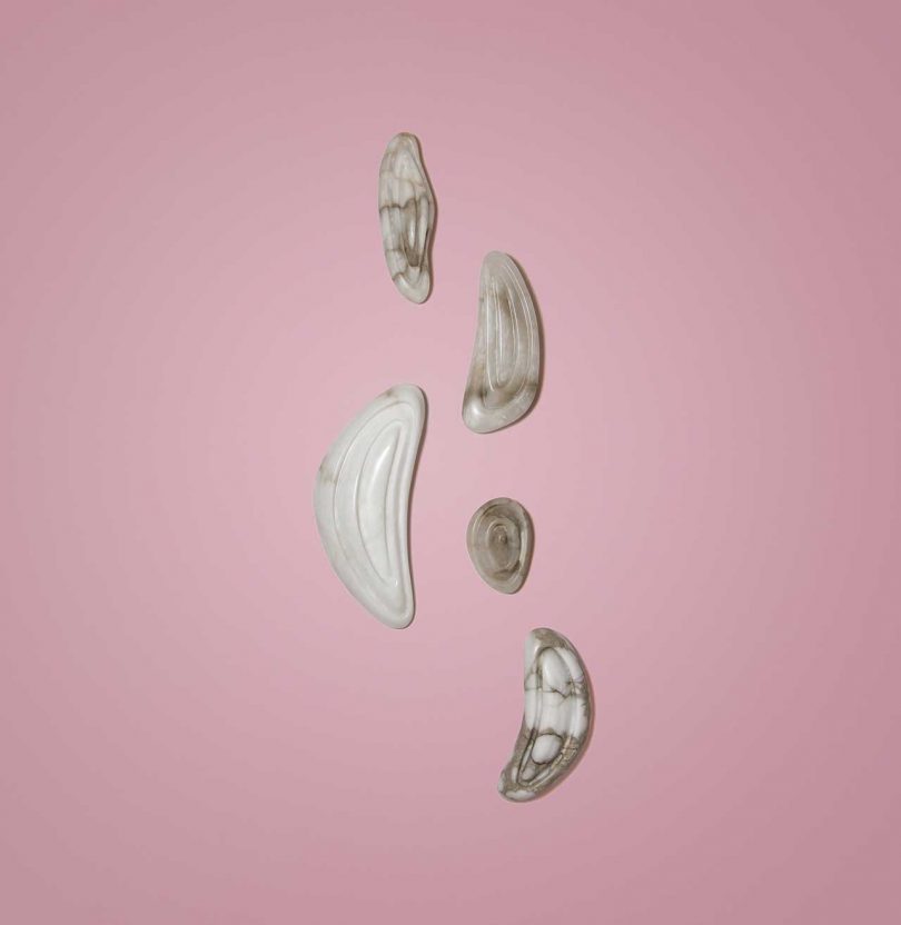 five abstract wall lights hanging on pink wall