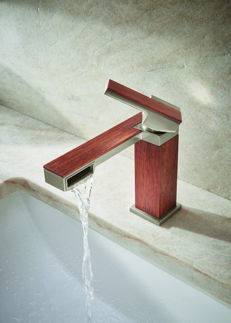 single handlr faucet in teak wood and metal turned on and flowing into sink