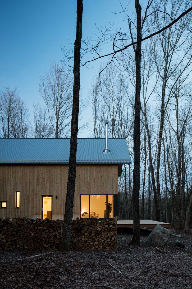 modern wood cabin in the woods at twilight