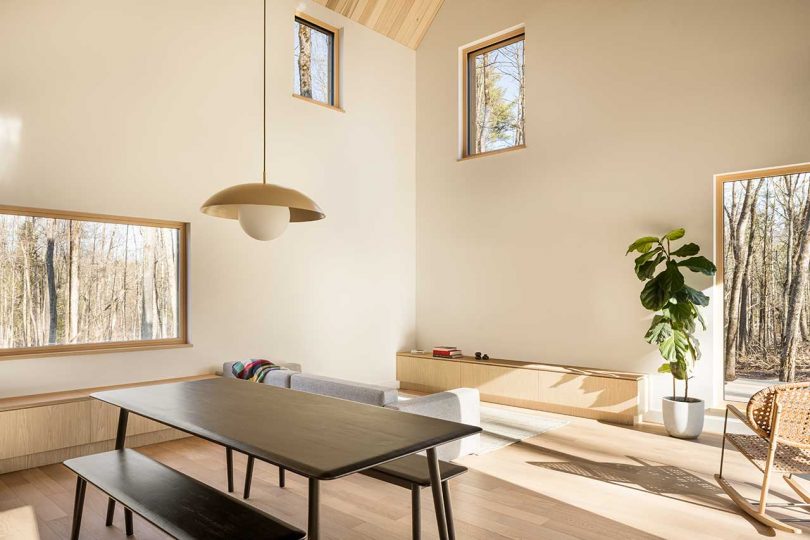 double-height living room in cabin with light woods and sparse furnishings