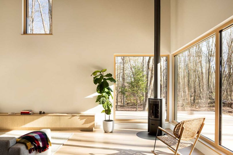 corner of modern living room in cabin with windows looking out to forest