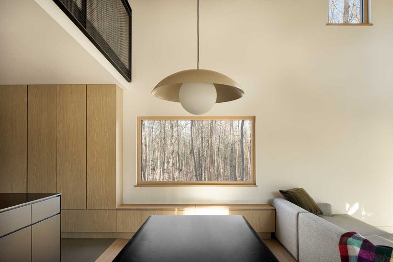 corner of modern living room in cabin with windows looking out to forest