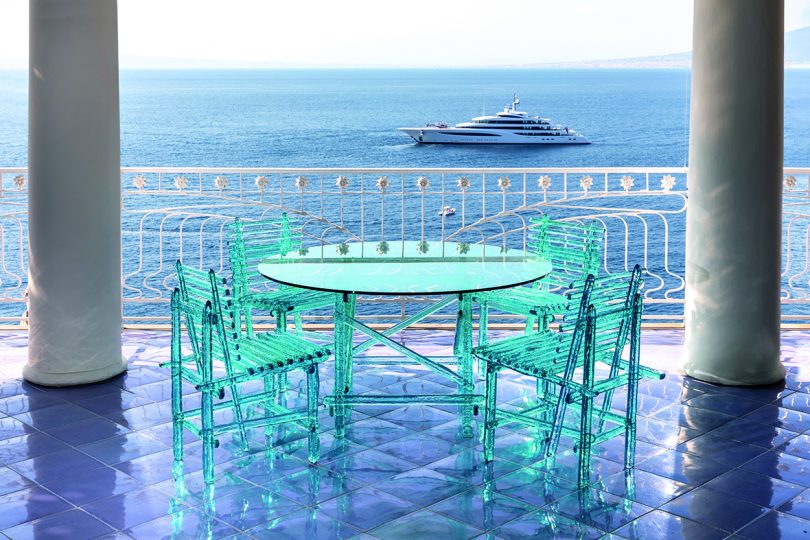 acrylic turquoise outdoor table and chairs overlooking the ocean and a yacht