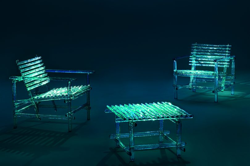 acrylic turquoise outdoor chairs and coffee table in dark space with dramatic lighting