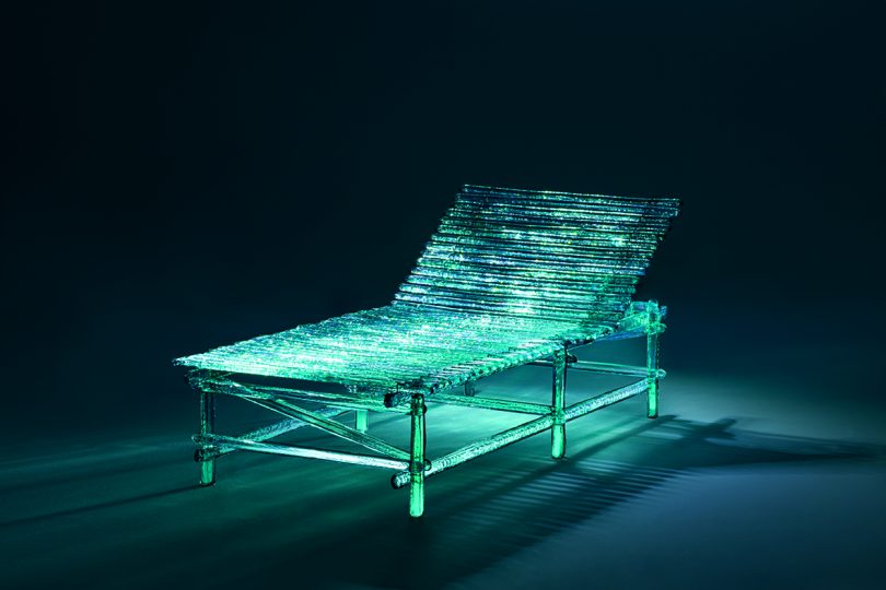 acrylic turquoise outdoor chaise lounge in dark space with dramatic lighting