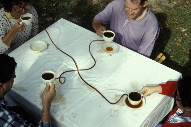 art installation with four people and cups of black coffee