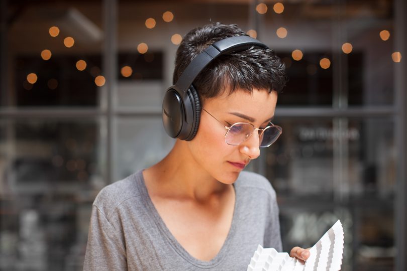 light skinned woman with short dark hair wearing glasses and headphones
