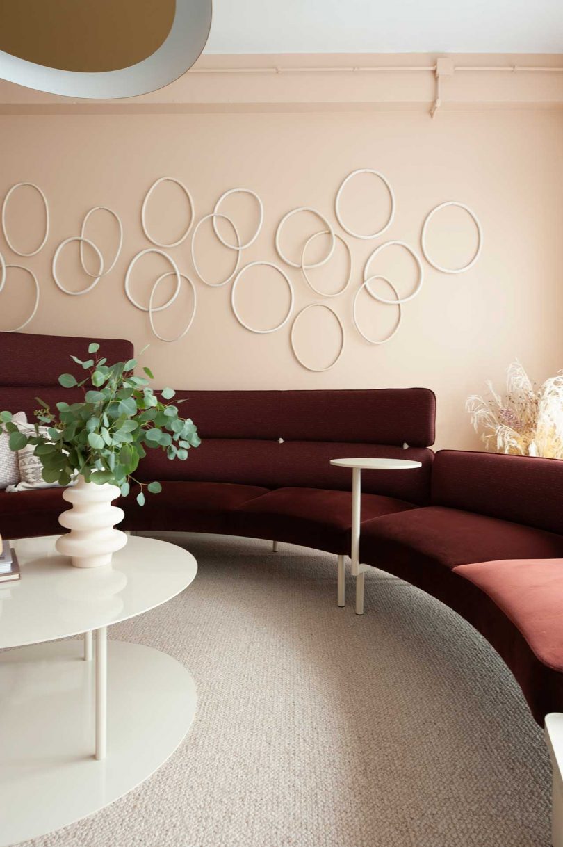 modern seating area with burgundy curved sofa