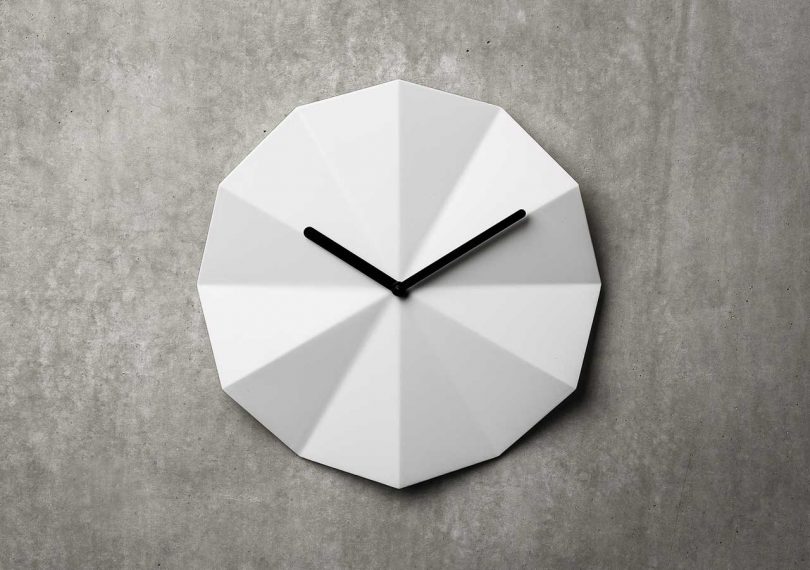 white clock with black hands and faceted face