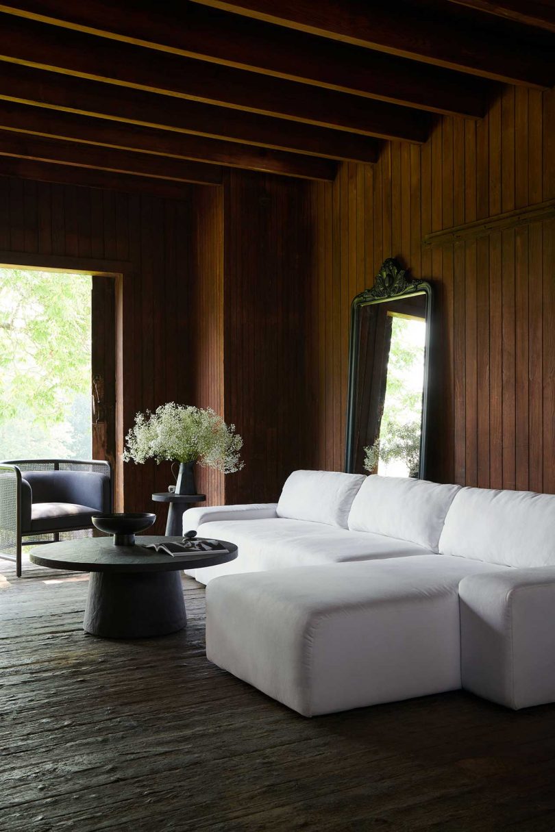 dark wood paneled living space with white sofa