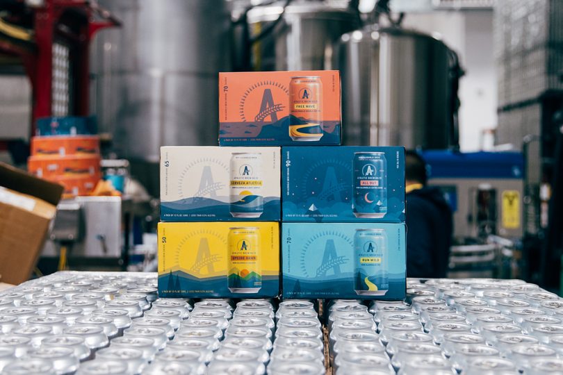 five 6-pack boxes of Athletic alcohol free beer stacked in a factory