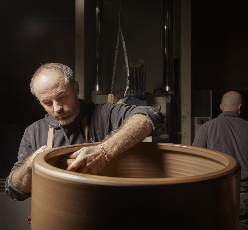 light-skinned man working on large piece of pottery