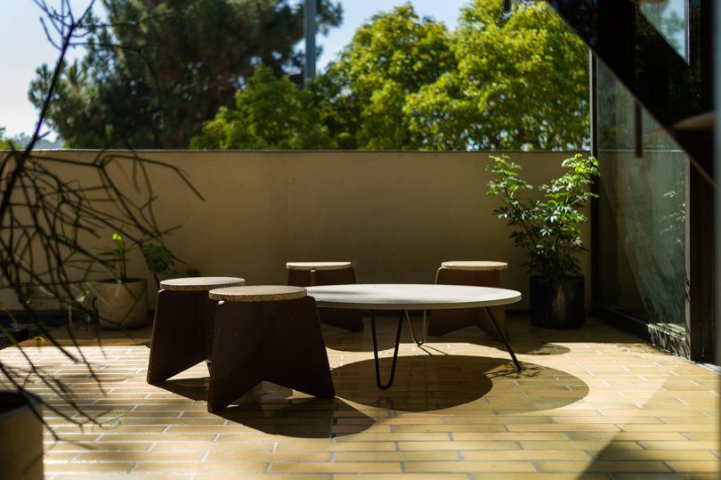 outdoor space with table and four stools in front of fence