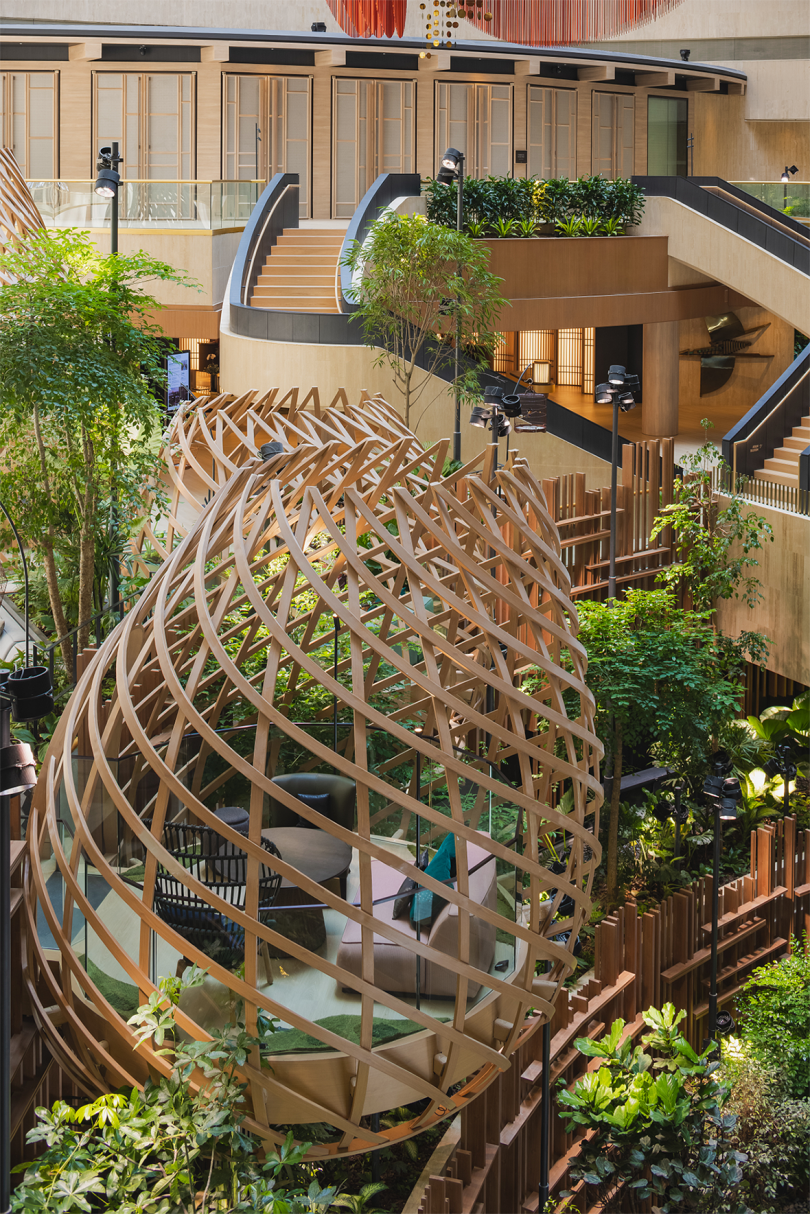 nest-like structure with interior seating surrounded by greenery