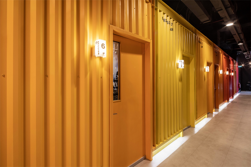 corridor of orange and yellow shipping container rooms