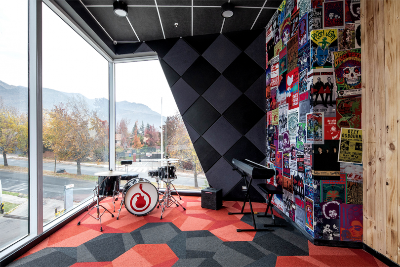 interior corner space with large windows, drum kit, and wall of posters