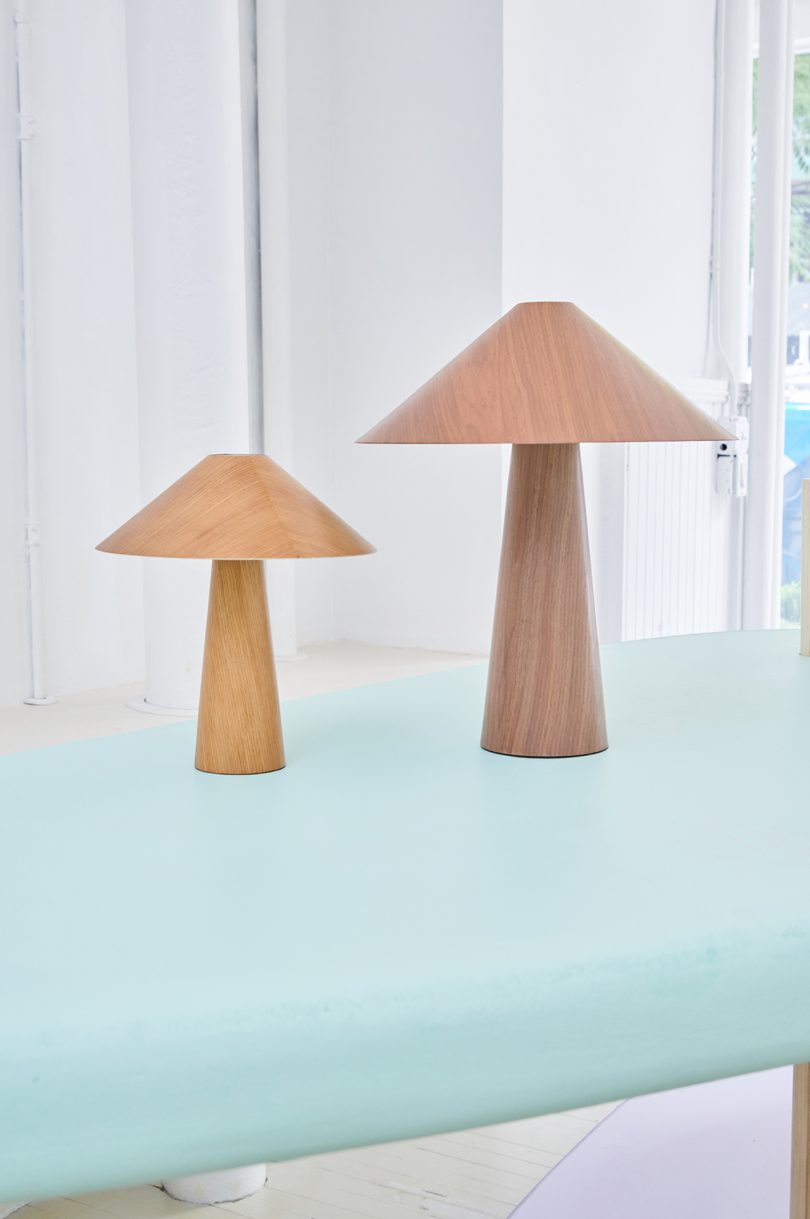 two wooden lamps on light blue surface