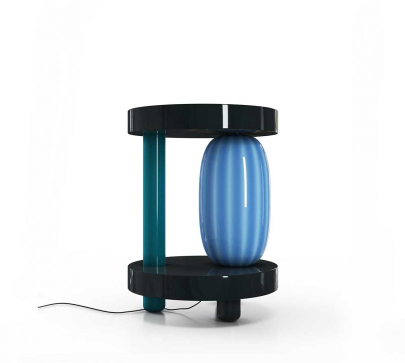 blue and black sculptural lamp on a white background