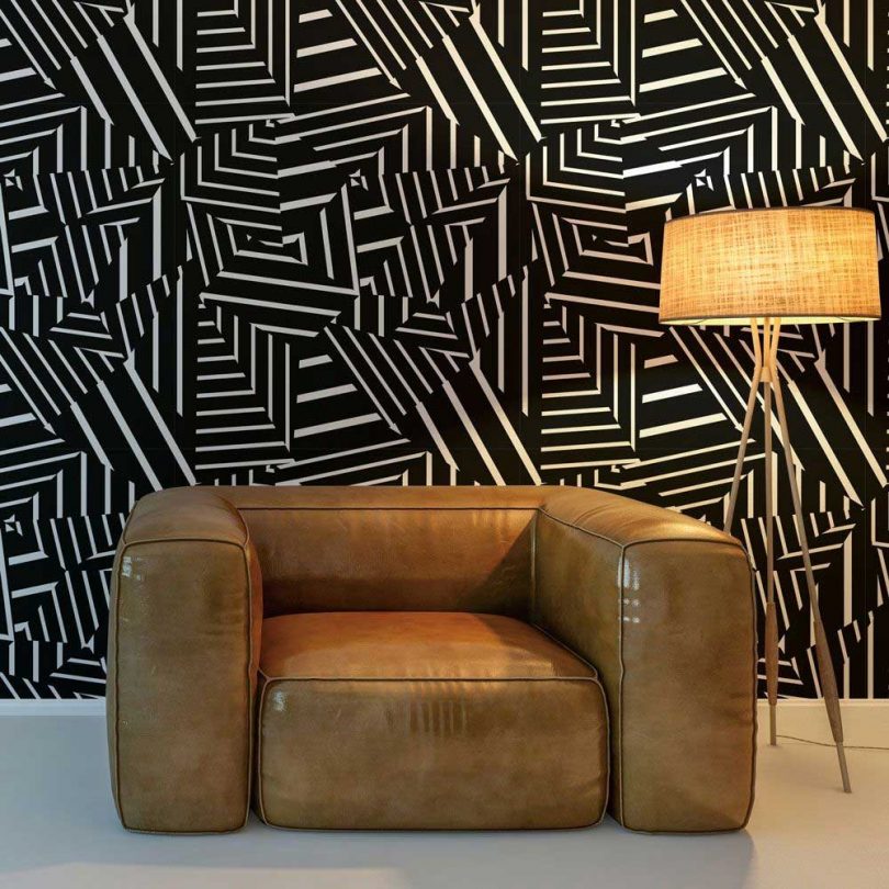graphic black and white stripe patchworked wallpaper with brown leather chair and lamp