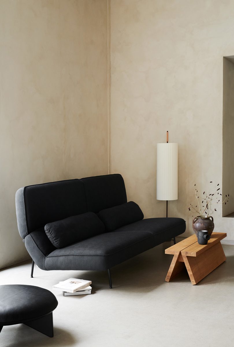black sofa in living space with coffee table and floor lamp