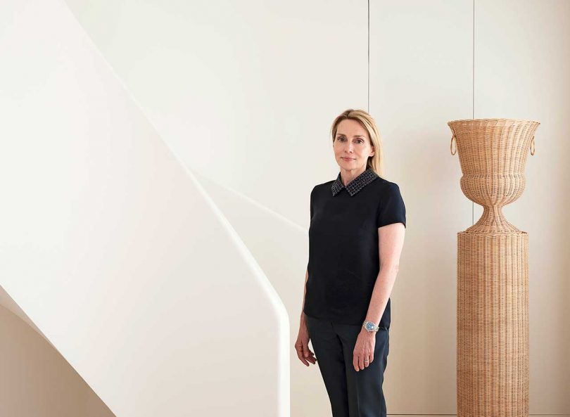 designer Isabelle Dubern-Mallevays standing in white space with curved stairs