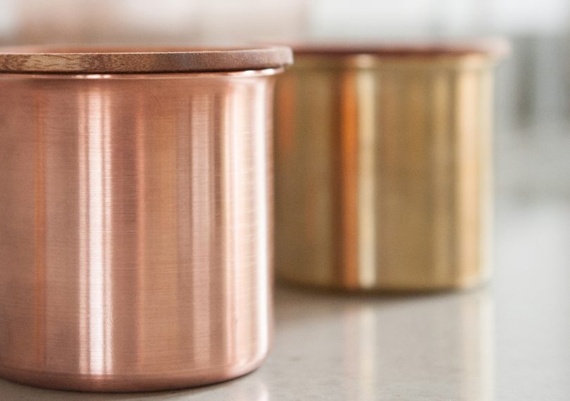 copper Ayasa food jar with a brass food jar behind it