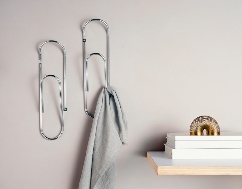 bendo wall hooks holding a small towel next to a shelf with books on it