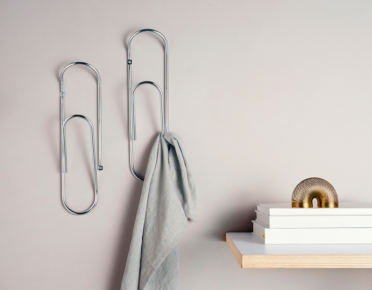 bendo wall hooks holding a small towel next to a shelf with books on it