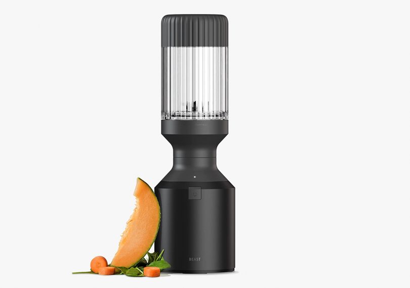 B10 Beast Health Blender in black on light grey background with a slice of melon next to it 