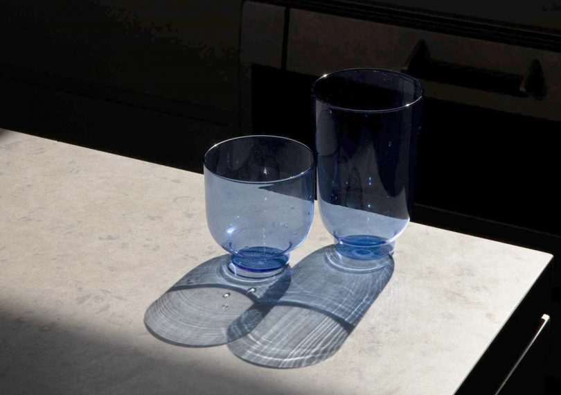 departo blue tinted high glasses on a table with intense shadow