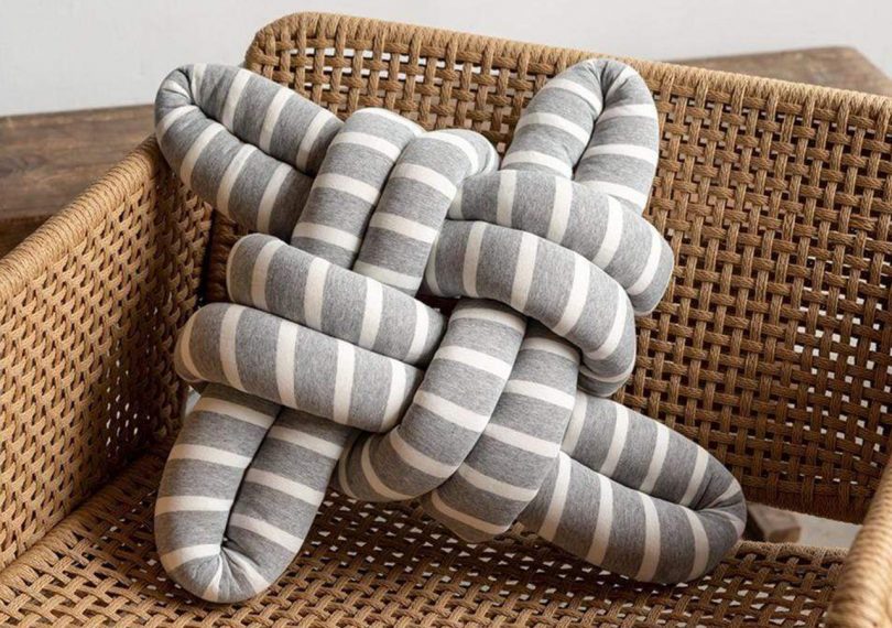 knots studio grey and white cotton knotted pillow on a chair
