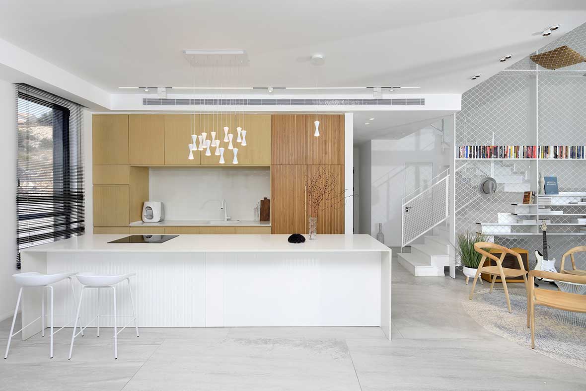 Colourful cabinetry offsets white interior of Bauhaus apartment in Tel Aviv