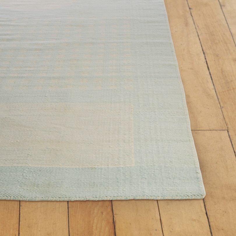 corner of light blue rug on wood floor