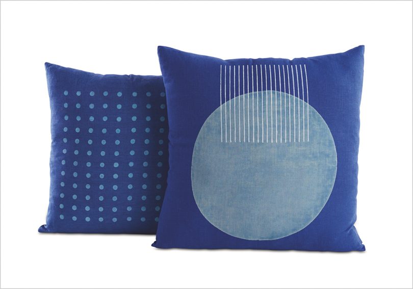 two blue patterned pillows on white background