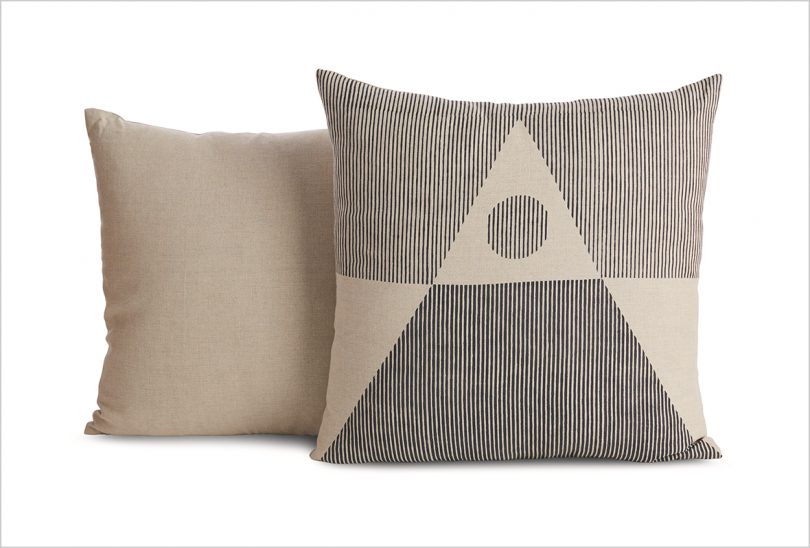 two cream and black patterned pillows on white background