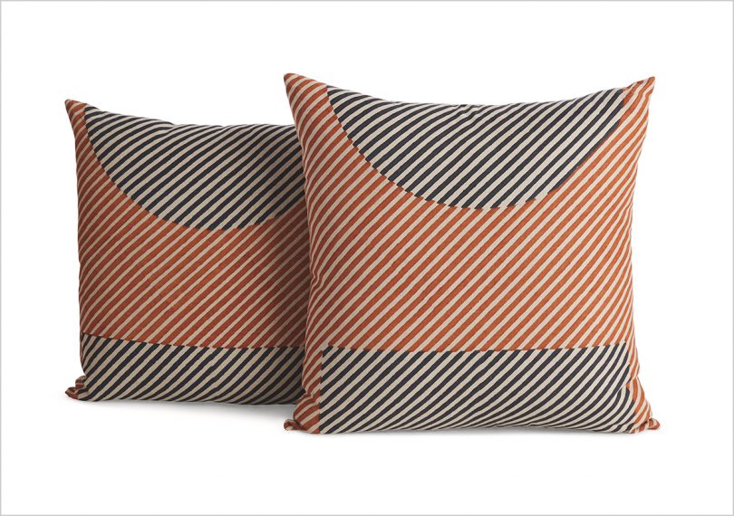 two rust and black patterned pillows on white background