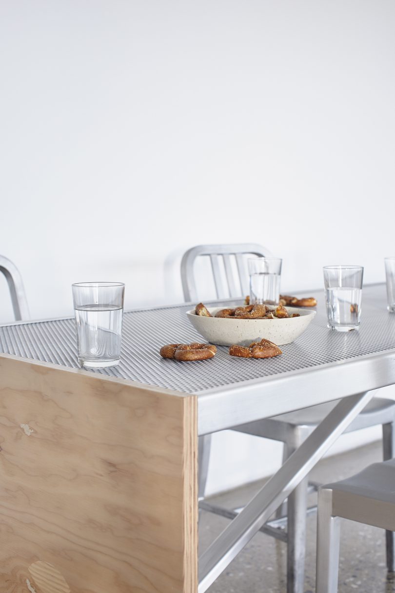 metal and wood table with pretzels and glasses of water