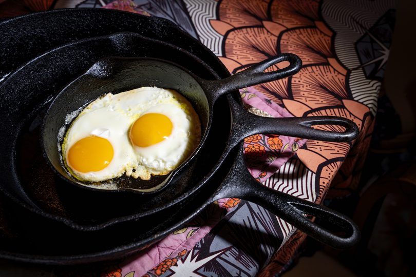 three nested case iron pans with two eggs sunny side up