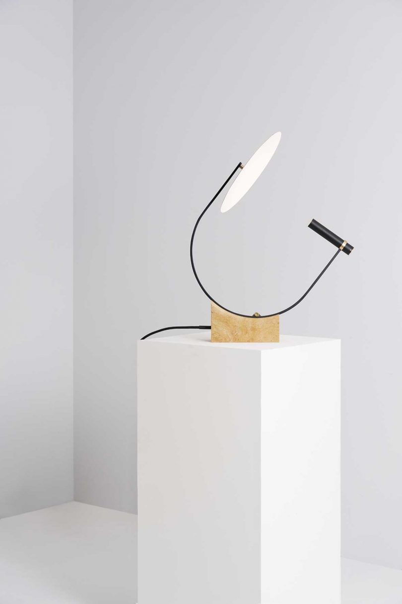 geometric table lamp on white plinth and background