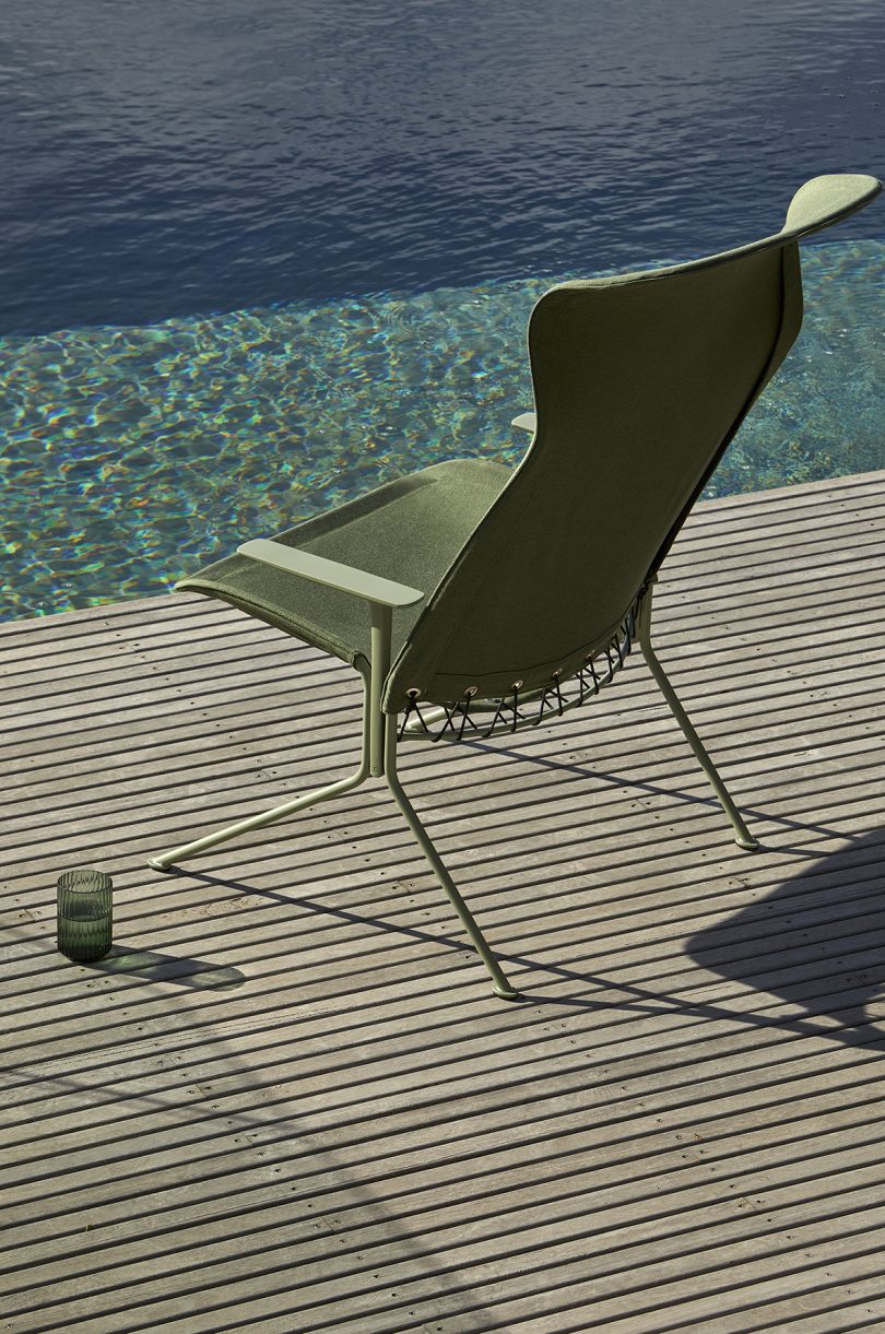 back of olive green lounge chair next to pool