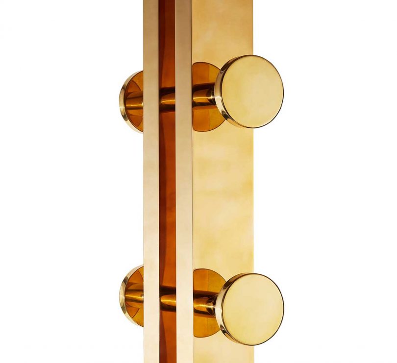 closeup of solid brass coatrack with circular knobs