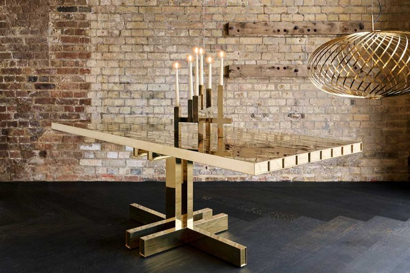 interior with rustic brick wall and solid brass dining table with candelabra and spring light pendant