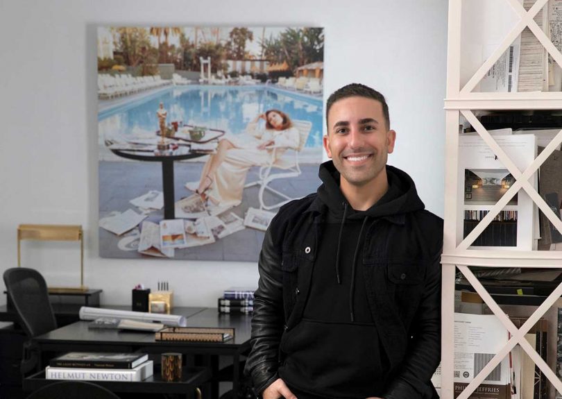 designer ryan saghian leaning against shelving in office