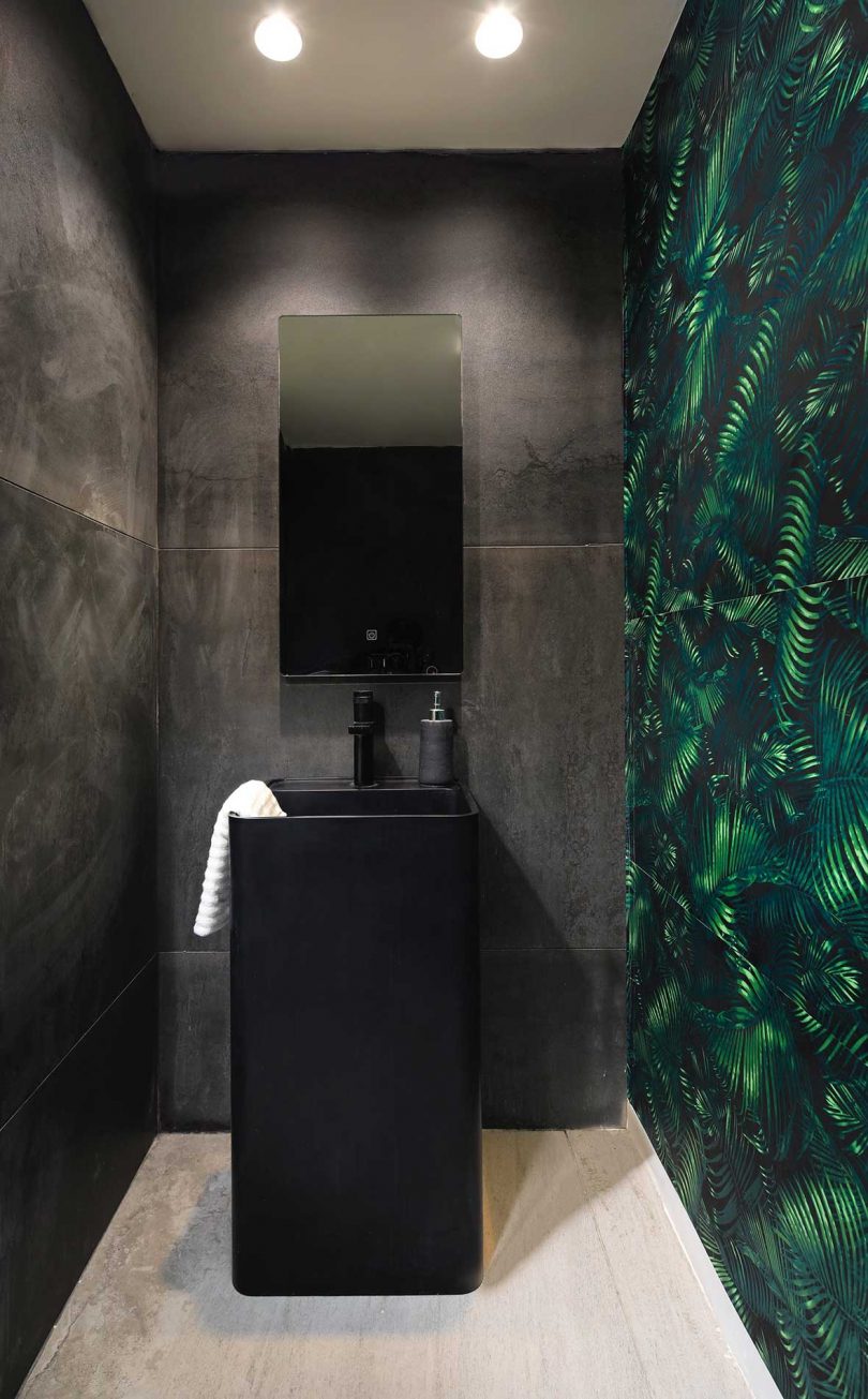 black bathroom with green wallpaper