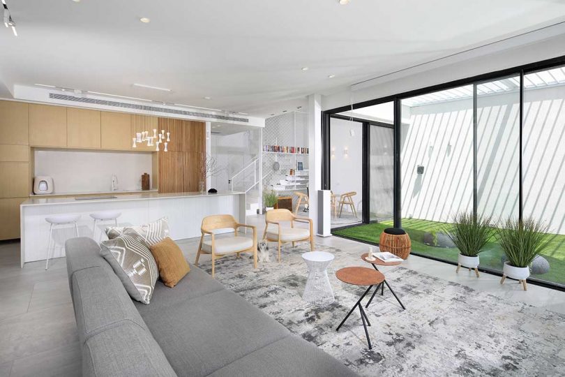 modern living room with views to white and wood kitchen and outdoor space