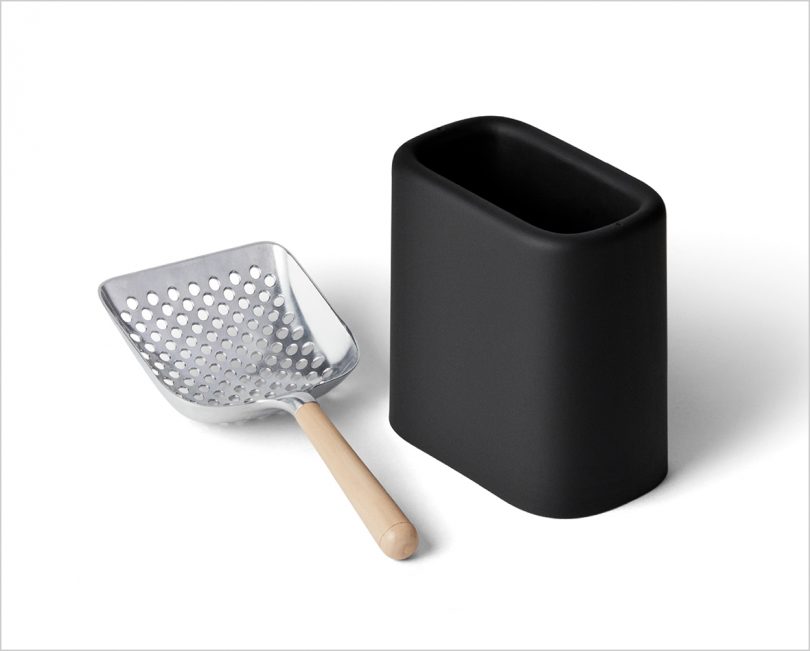 metal and wood litter scoop with black holder on white background