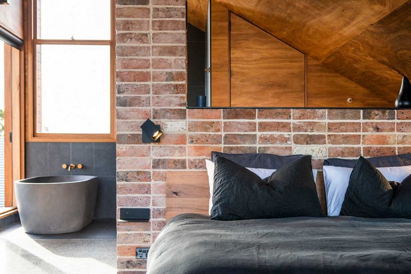 interior of modern hut with bed under slanted wood ceiling