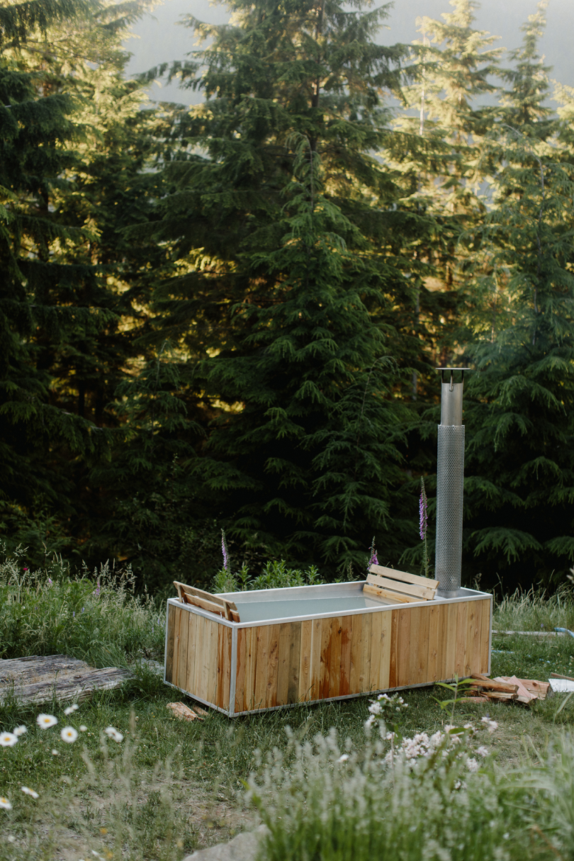 wood burning hot tub in an open green space