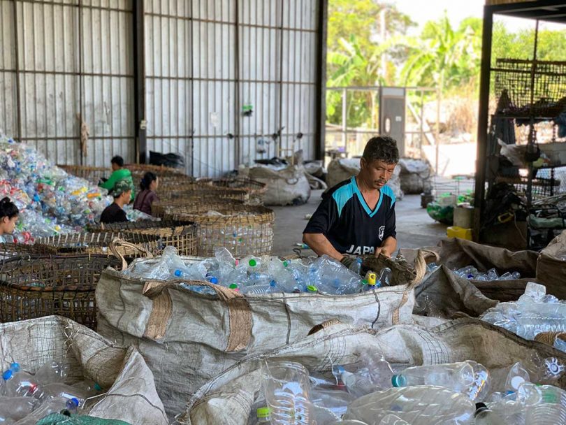man working in facility sorting plastic bottles