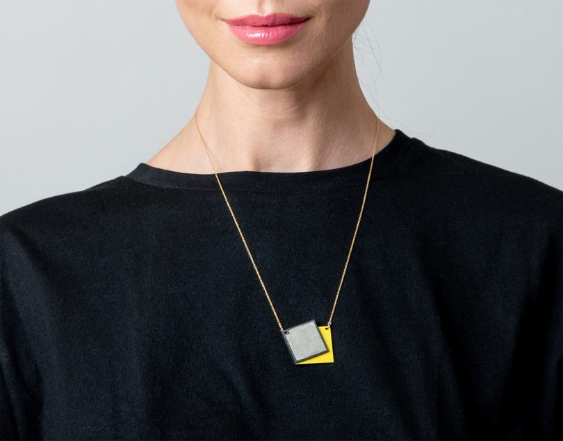 light-skinned woman wearing black shirt and colorful concrete necklace